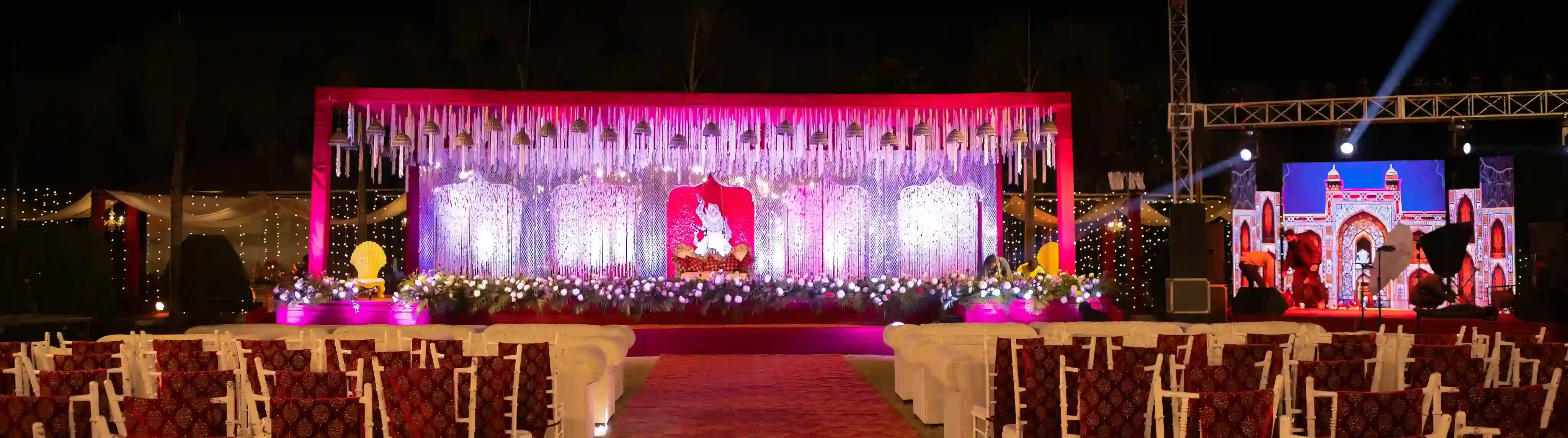 Wedding photography at Taj Ganges Varanasi - decorated stage backdrop, red-carpet aisle and fairy lights in the banquet hall by The WeddingShoot